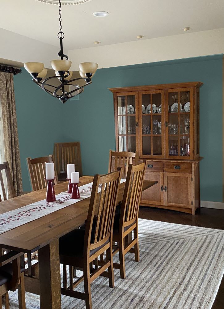 dining room with teal walls and wood hutch