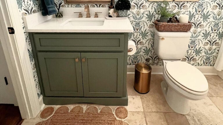 1990s bathroom, travertine tile floor, green painted vanity, white quartz, update with wallpaper and gold hardware