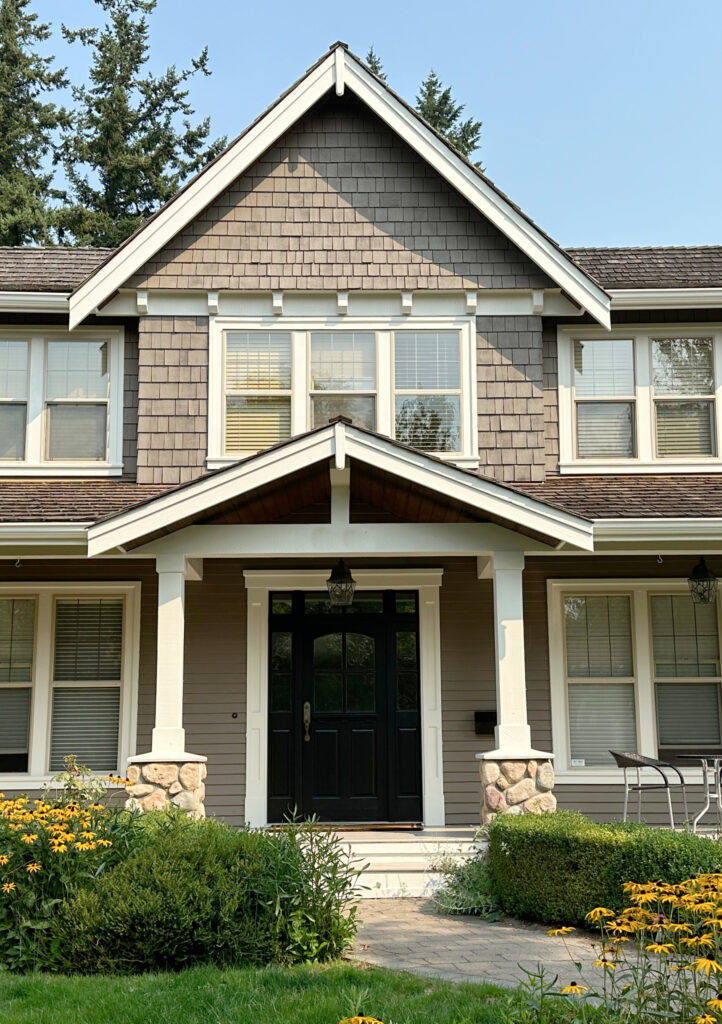 Almond, bone, beige or tan windows, warm white trim, greige taupe paint color on exterior siding, cedar shake shingle roof, river rock accents