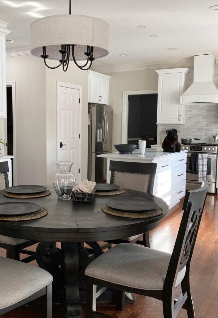 Benjamin Moore Natural Cream paint color on walls, white cabinets, round kitchen table, quartz and island