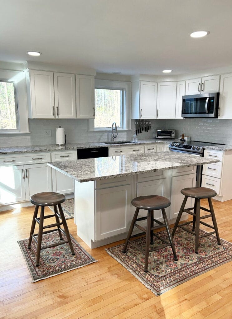 Granite countertops, subway tile backsplash in gray, Benjamin MOore White Dove painted cabinets, trims, walls, ceiling, nickel hardware, stainless steel kitchen