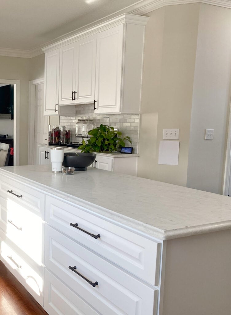 Off-white quartz countertop, white cabinets, Benjamin Moore Natural Cream paint color on walls