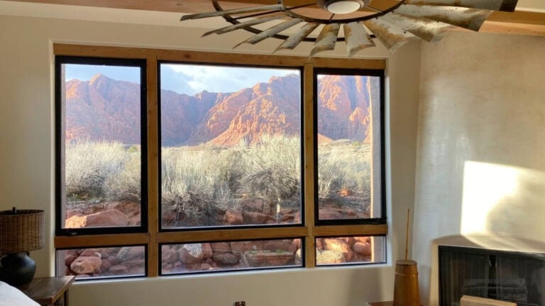 Sherwin Williams Natural LInen in arizona type setting, wood trims, black windows, adobe style fireplace in bedroom