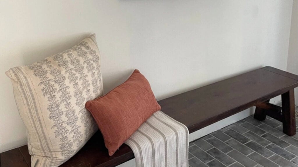 Benjamin MOore Simply White walls, gray brick flooring and bench in entryway