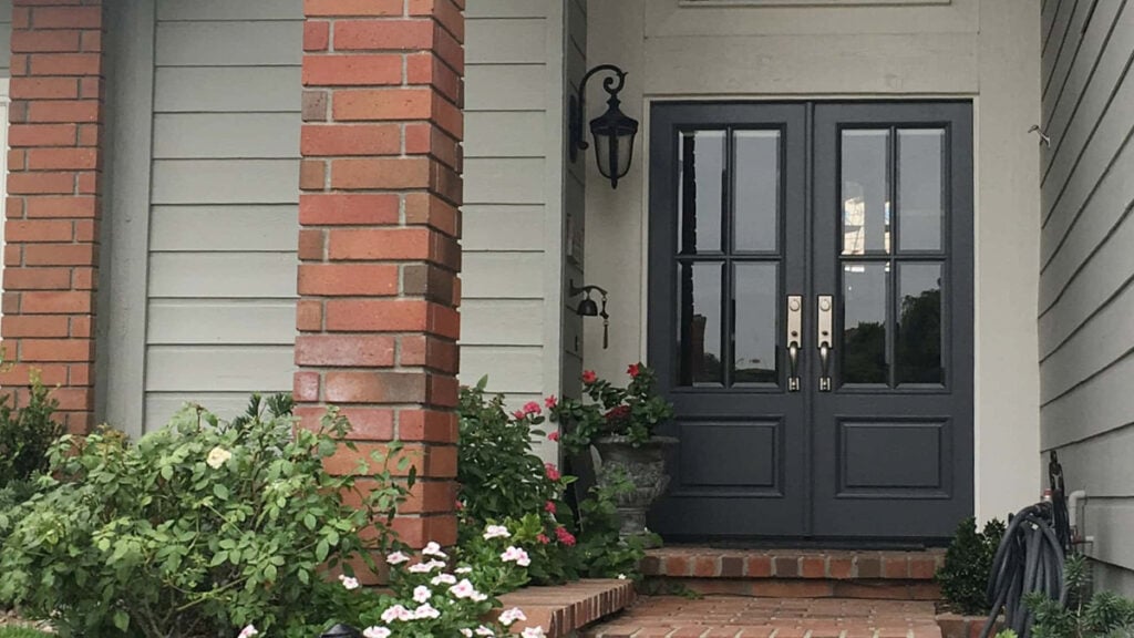 Benjamin Moore Cheating Heart painted front door with gray-green siding and red-orange brick