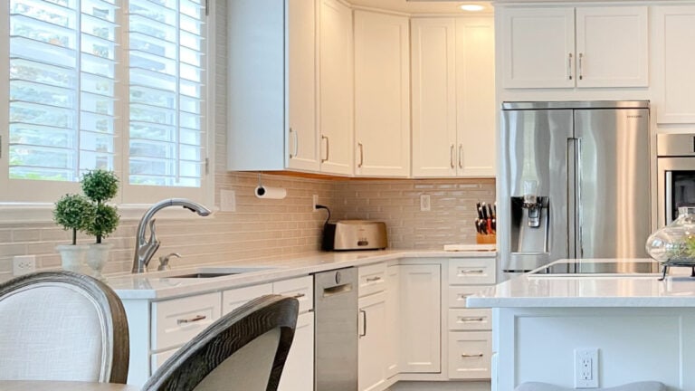 2000s kitchen update with Benjamin Moore White Dove cabinets, Ironsbridge quartz countertop, taupe subway tile backsplash