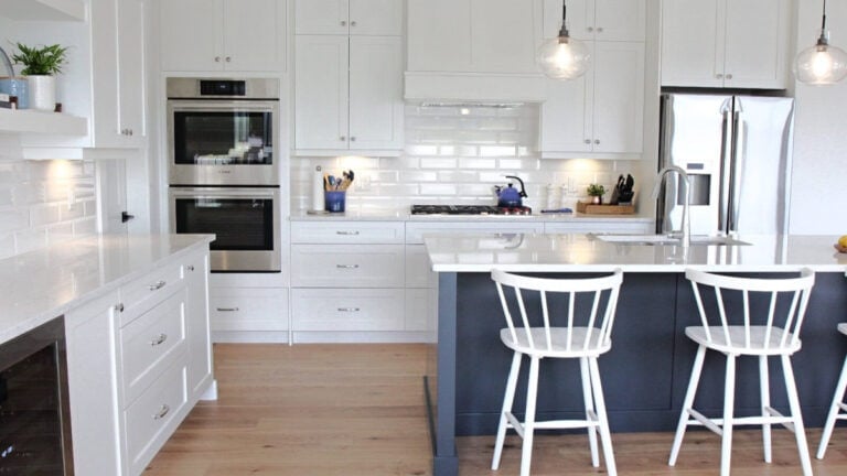 Main kitchen cabinets are Sherwin Williams Pure White, the island is a navy blue - Cyberspcae. White quartz countertops and oak wood flooring, south-facing