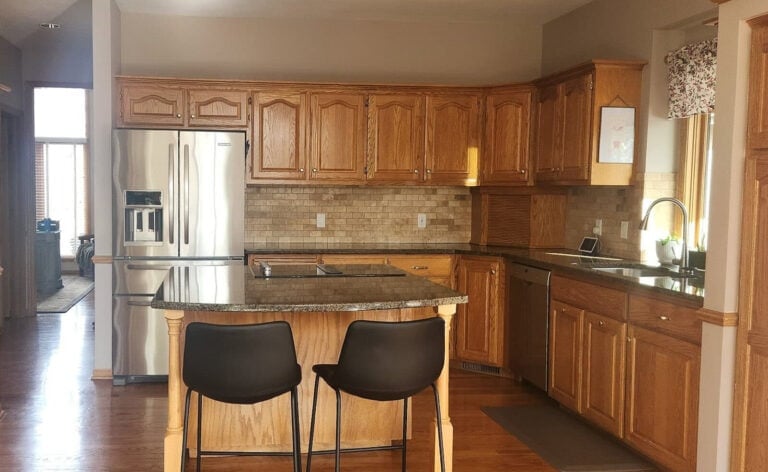 Update 1990s home ideas, shown here golden oak cabinets with granite countertop and travertine tile backsplash