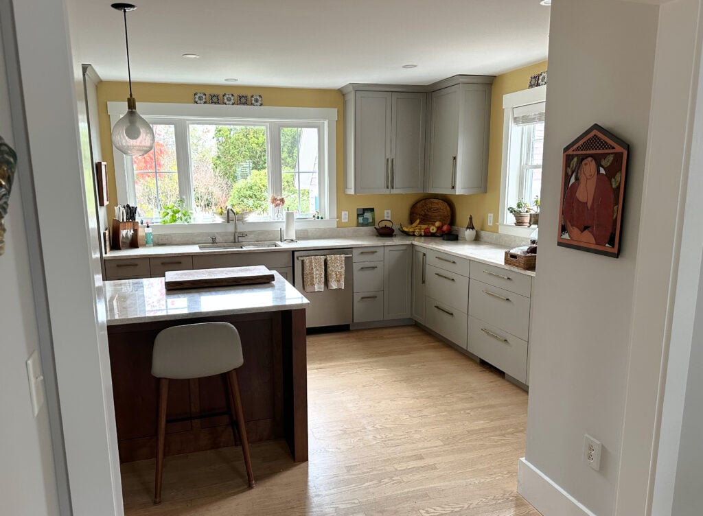 Benjamin Moore Da Vinci's Canvas yellow golden paint color on kitchen walls, Pavestone painted cabinets, Taj Mahal quartzite countertops, white oak flooring and wood island