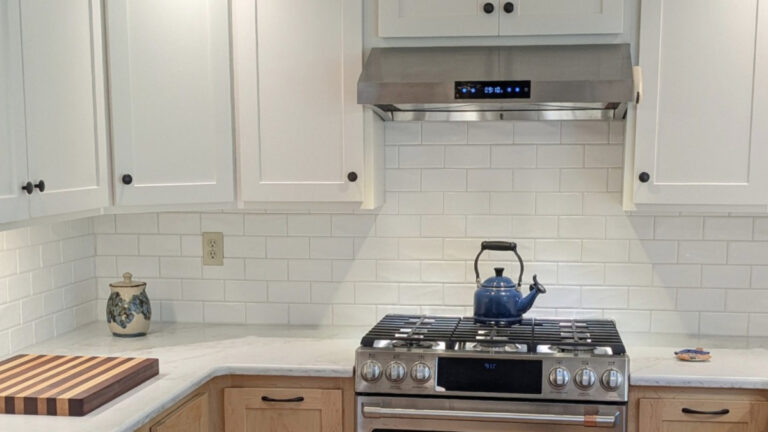 Sherwin Williams Alabaster in kitchen with white subway tile, off-white quartz countertop and maple natural finish wood lower cabinetsl