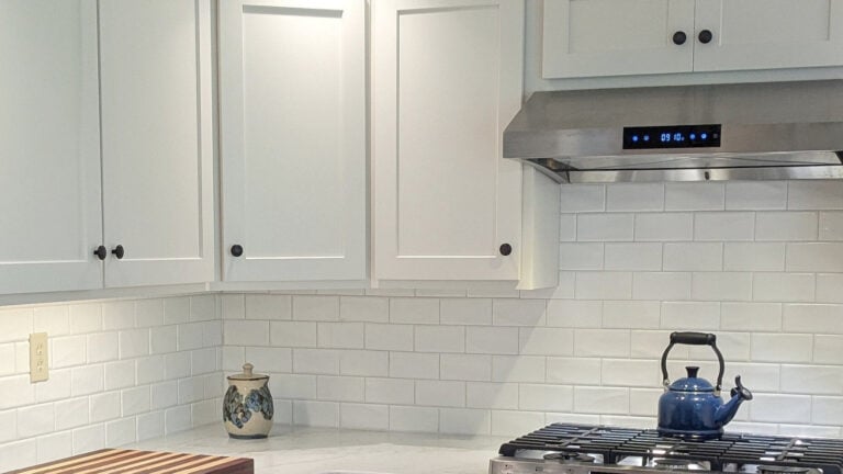 Sherwin Williams Alabaster painted kitchen cabinets, subway tile backsplash with white quartz countertops in country style kitchen