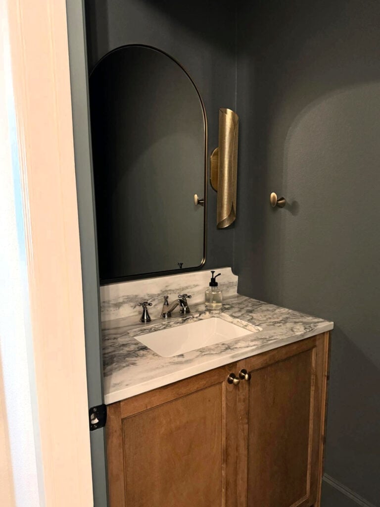 Sherwin Williams Homburg Gray in small bathroom, powder room, wood vanity, brass gold lights, marble countertop