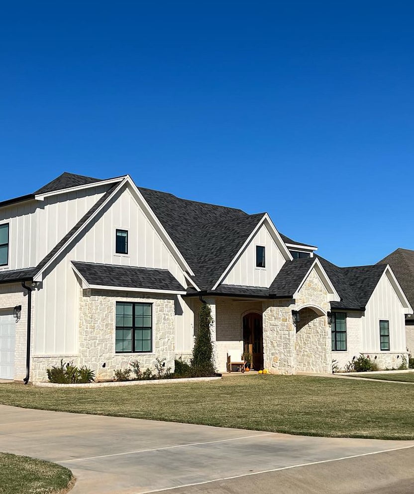 exterior with cream, beige, taupe stone, Sherwin Williams warm off-white taupe exterior paint color, black windows, dark fiberglass roof
