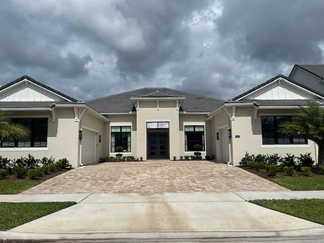 florida home exterior, fiberglass roof, stone orange pink gray driveway, light tan paint color, white trim, black windows