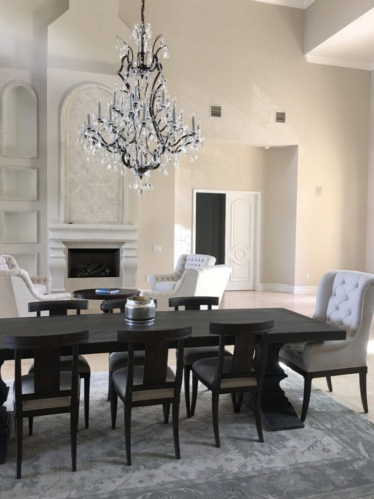 Benjamin Moore Manchester tan in traditional style open-concept dining and sitting room, vaulted fireplace with stone surround