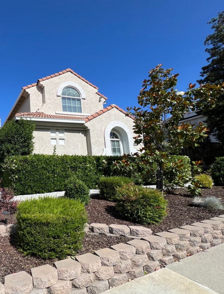 South-facing Exterior with red tile, terra cotta accent roof, warm off-white beige color on stucco, white windows, pink beige concrete driveway