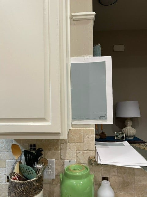 Sherwin Williams Dover White painted kitchen cabinets, travertine tile backsplash. Mineral Deposit gray blue for walls