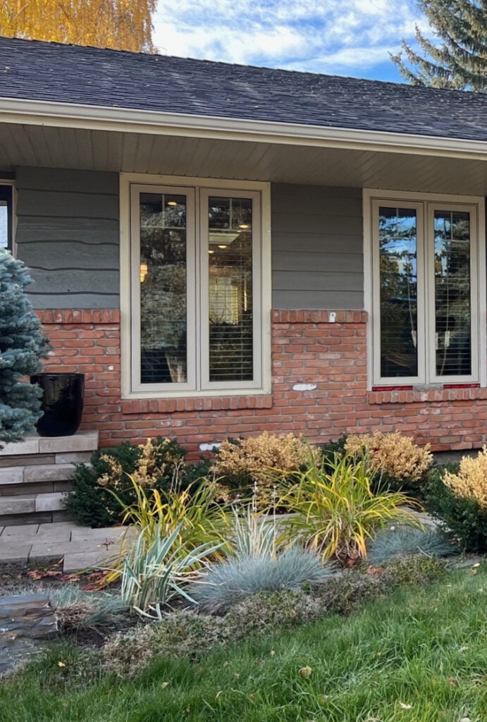 exterior red pink brick with green greige paint color on painted wood siding, tan, beige almond windows, gray roof