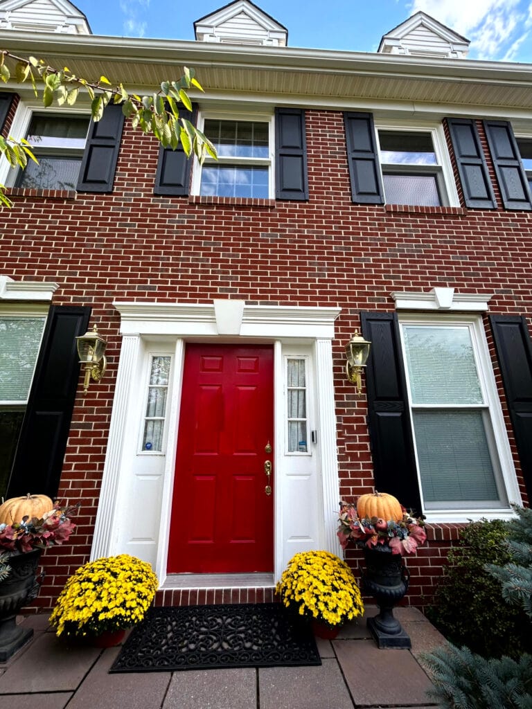 red brick external palette, black shutters, white trim, bright red front door, gorgeous colour palette