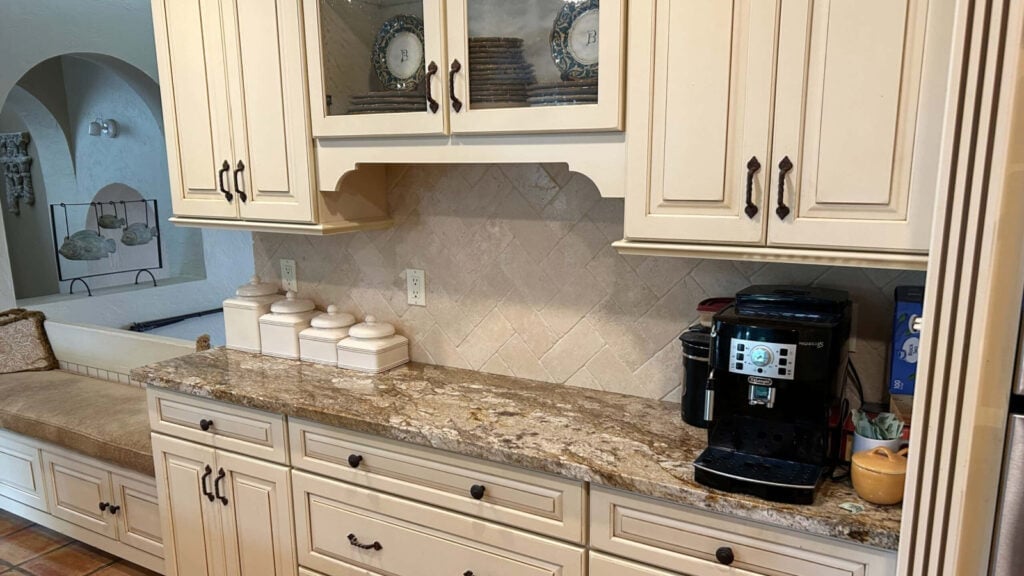 Cream cabinets with glaze that need updating in tuscan home, granite countertop, travertine tile backsplash