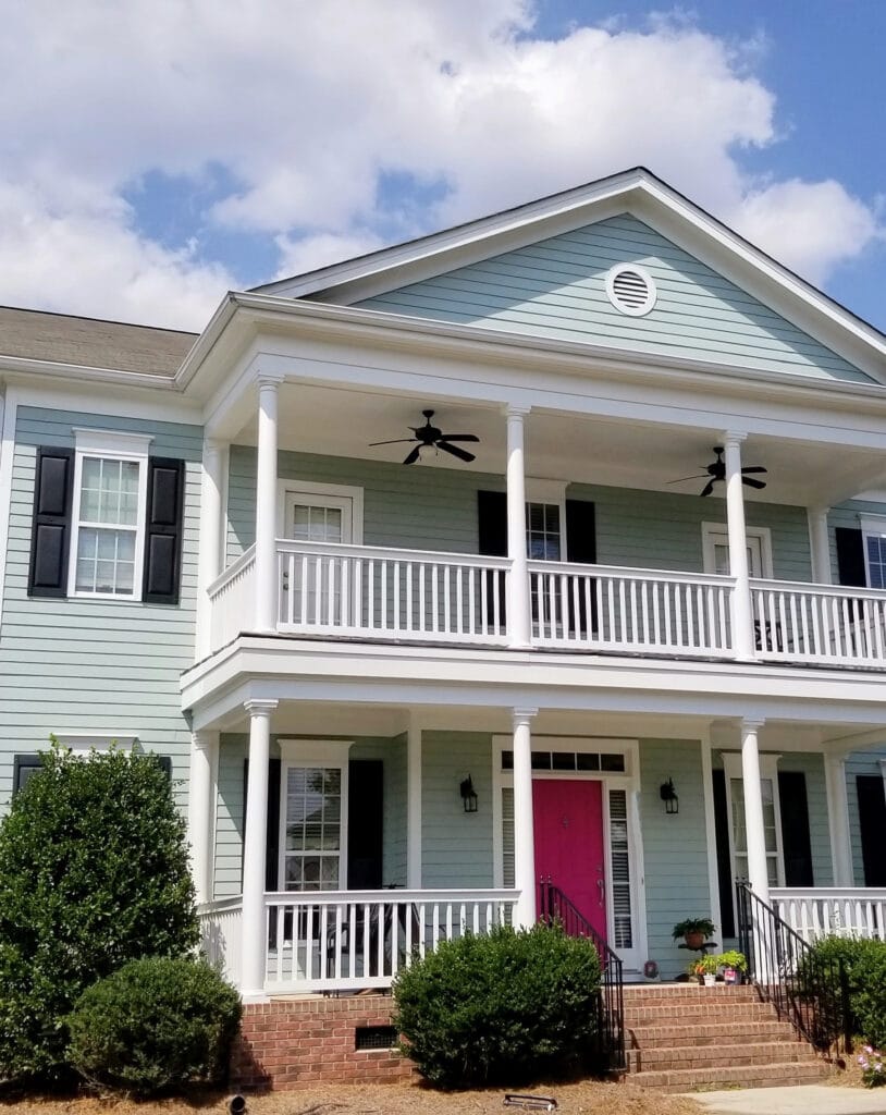 Sherwin Williams Quietude exterior blue-green paint color, white trim, black shutters, pink front door paint color palette, orange-pink brick steps