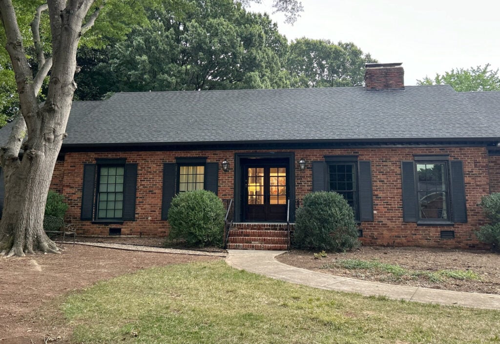 exterior with red orange brick, dark soft black shutters, painted windows, trims, double front door (3)