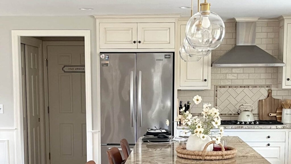 Cream cabinets with granite countertop, greige paint oclor on walls, creamy subway tile backsplash