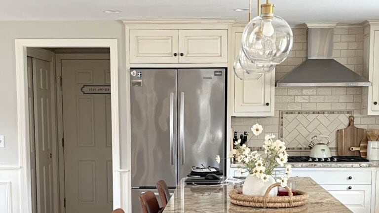 Cream cabinets with granite countertop, greige paint oclor on walls, creamy subway tile backsplash