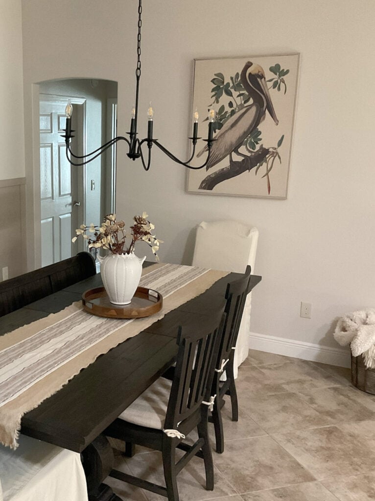 Beige and taupe tile floor, Sherwin Williams Aesthetic White, off-white paint color on walls, dark wood stained black dining room furniture