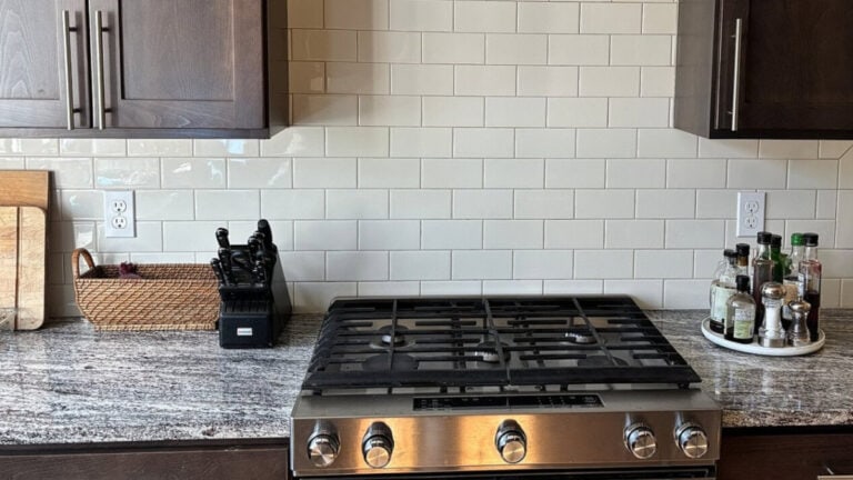 2000s kitchen with dark espresso wood cabinets, subway tile backsplash and granite countertops