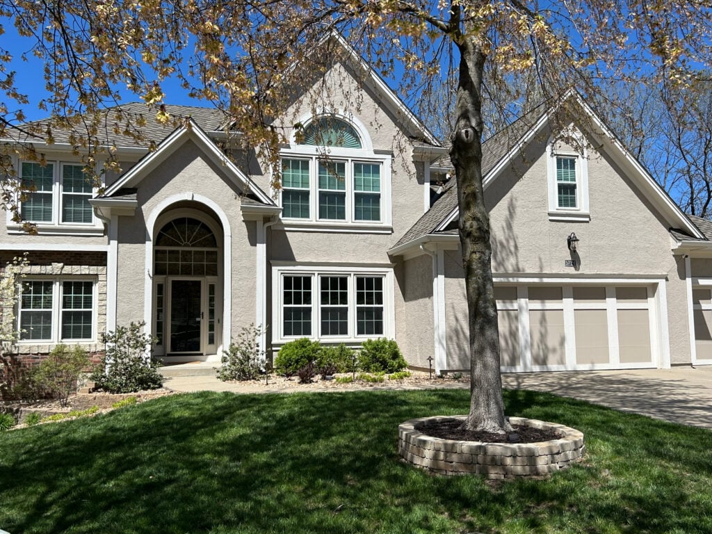Sherwin Williams Balanced Beige exterior stucco paint color, Aesthetic White trim color and garage door details, brick accents and a touch of stone, asphalt roof