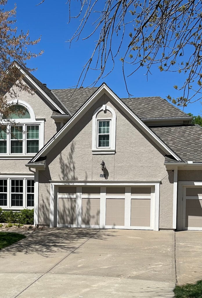 Sherwin Williams Balanced Beige painted exterior stucco with Aesthetic White on trim and garage door, asphalt roof