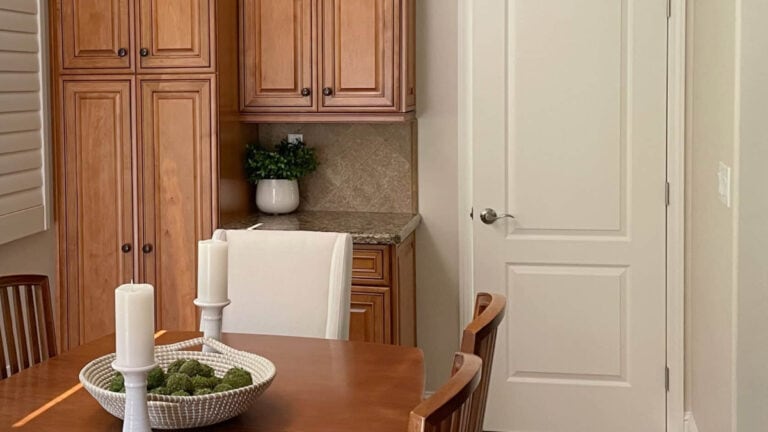 Sherwin Williams Moderate White interior door and trim with wood cabinets and dining table, Natural LInen walls