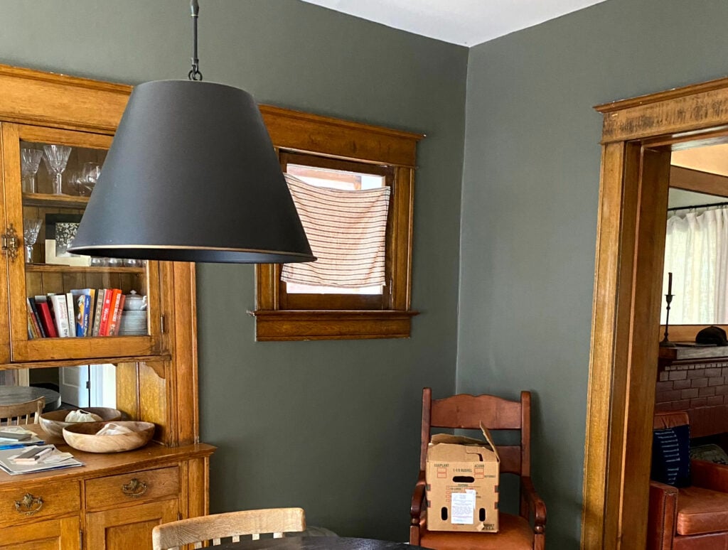 Benjamin Moore Castle Peak Gray, dark green paint color with orange stained wood trim in older home with wood floors