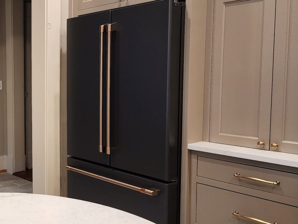 Cashmere kitchen ideas. GE Cafe Matte black kitchen appliances with gold coppper hardware, greige taupe kitchen painted cabinets, antique brass hardware.