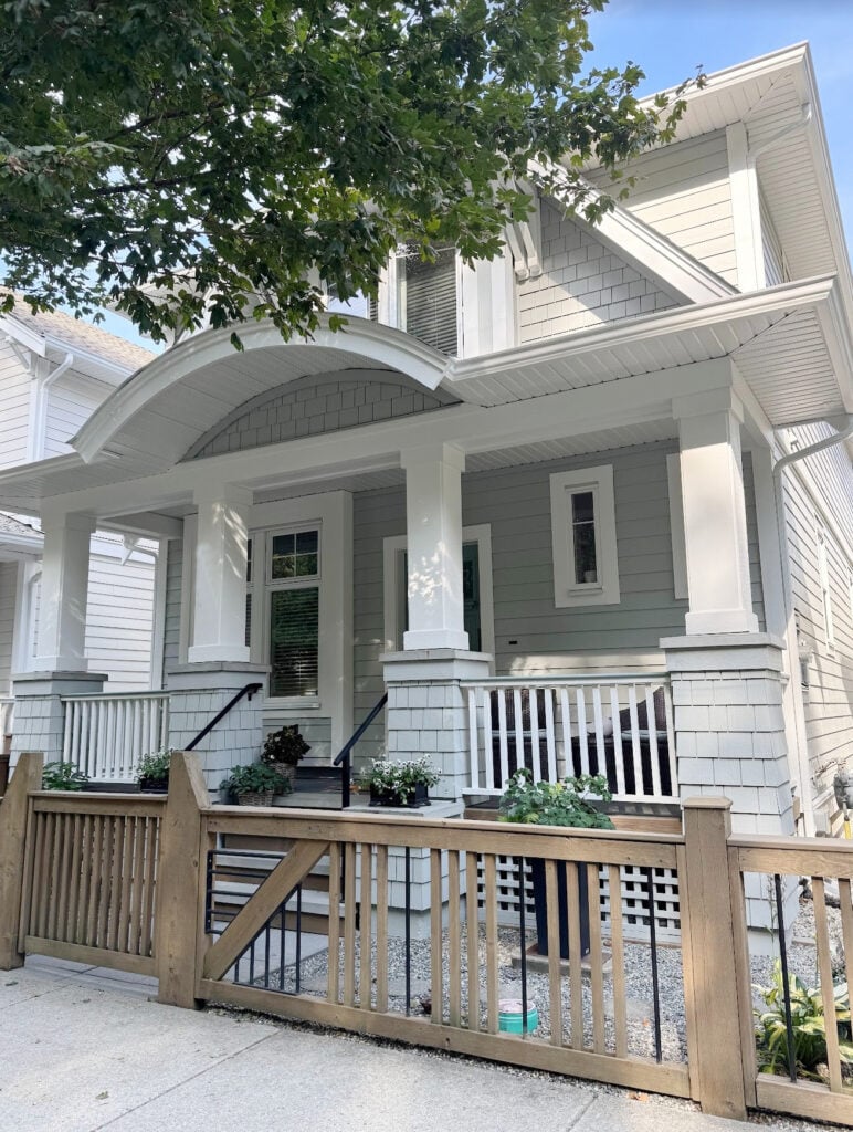 Exterior siding and shakes painted Benjamin Moore Gray Horse, gray-green paint color, Sherwin Williams Pure White trim and curved gable