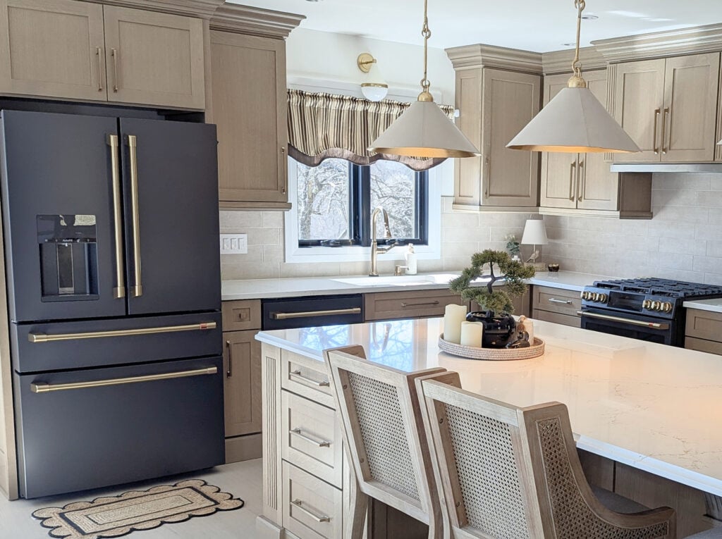 GE Matte black fridge appliances, Cold Foam walls, Zellige tile backsplash, brushed brass hardware, staineed oak beige-wash wood floor, white quartz island, Vicostone, Misterio Gold, wood rattan stools
