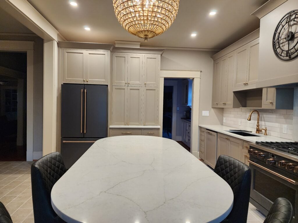 Kitchen with greige taupe painted wood cabinets, off-white cream trim, Ge Cafe Matte Black fridge, stove, and appliances, soft white quartz countertop, gold hardware, Kylie M Interiors Edesign