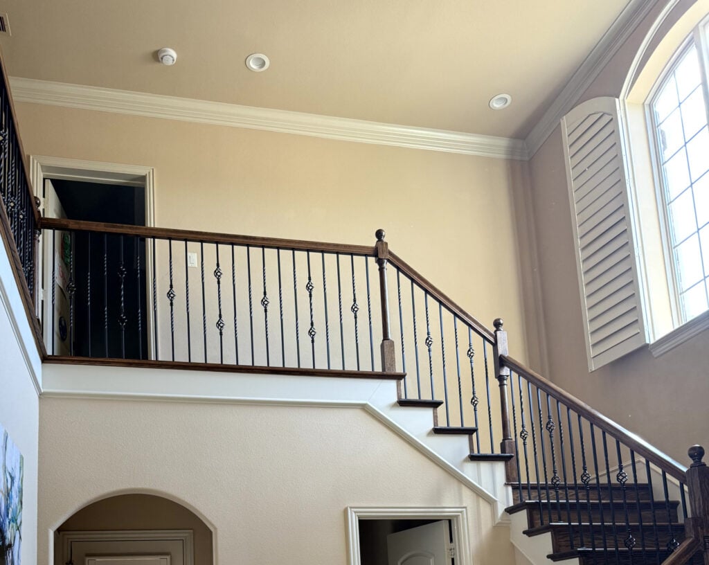 Similar to Sherwin Williams Kilim Beige in 2000s Tuscan style entryway and staircase with wood railing and cream trim