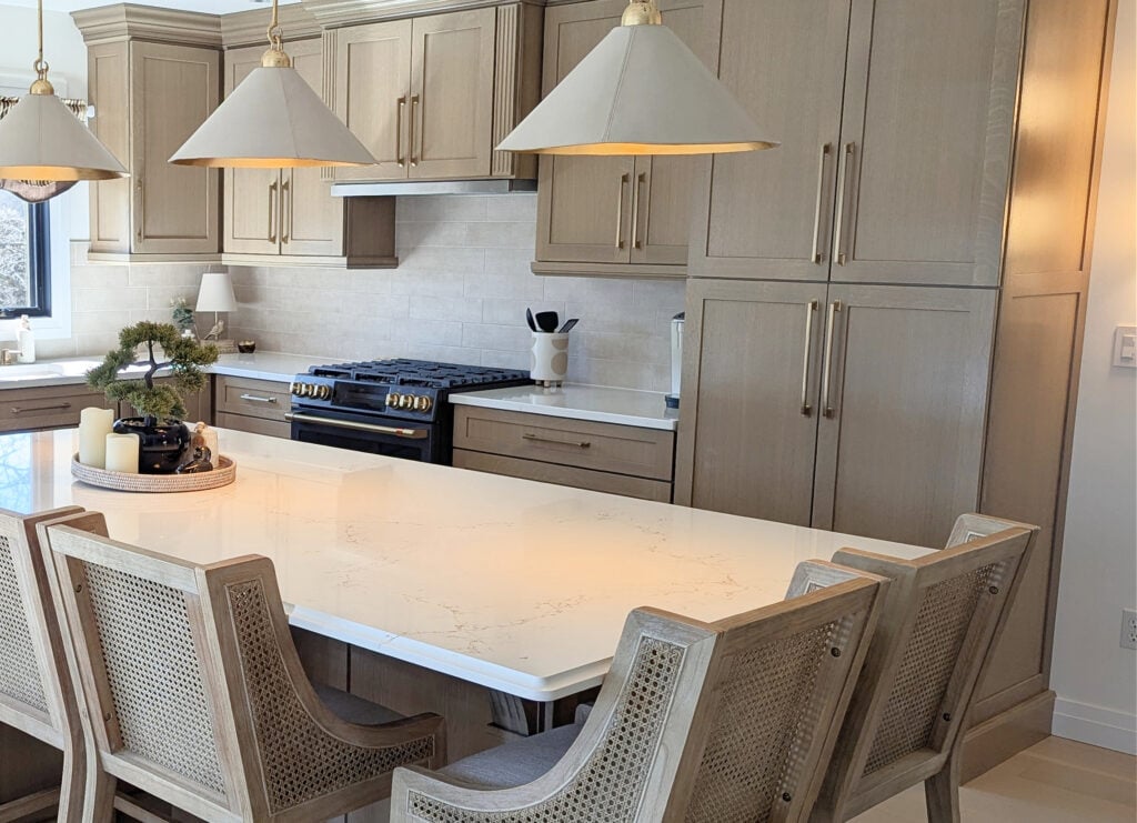 custom stained paint beige-wash wood cabinets, island, white quartz, Vicostone Misterio Gold, wood rattan stools, gold hardware, matte black oven, zellige backsplash