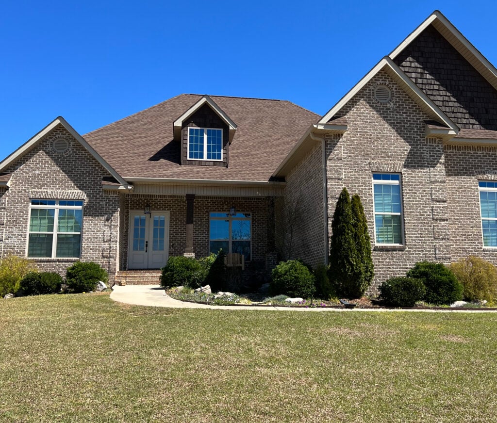 Benjamin MOore Edgecomb Gray trims and windows on brown-pink exterior brick of home with taupe roof.