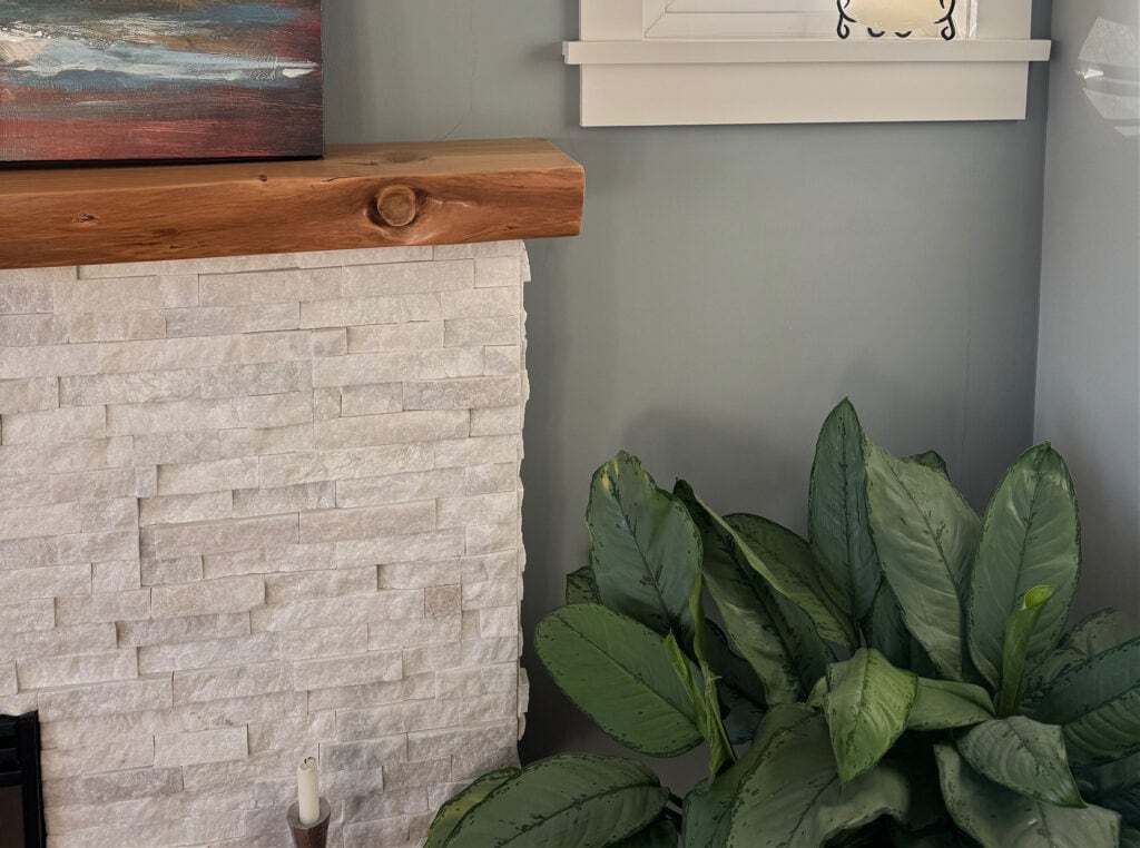 BEnjamin Moore Puritan Gray on walls with a whit stone fireplace. Cloud White on the trims