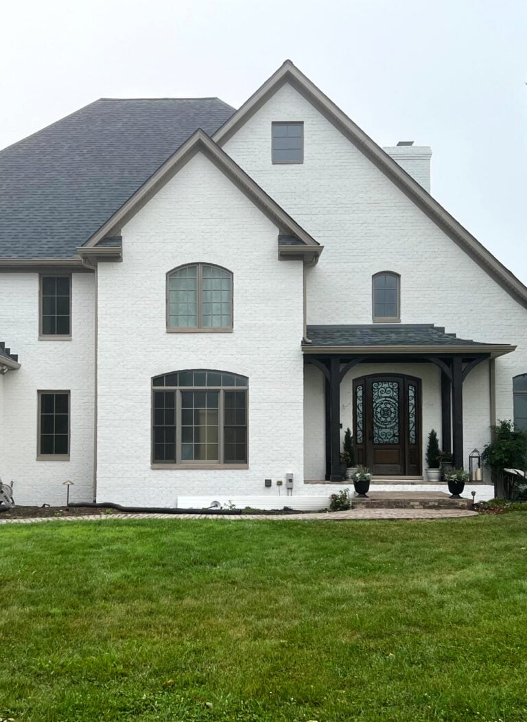 Benjamin Moore SEa Pearl on painted exterior brick used to be pink. Brown greige trims and windows. Best warm off-white paint color for exterior of home