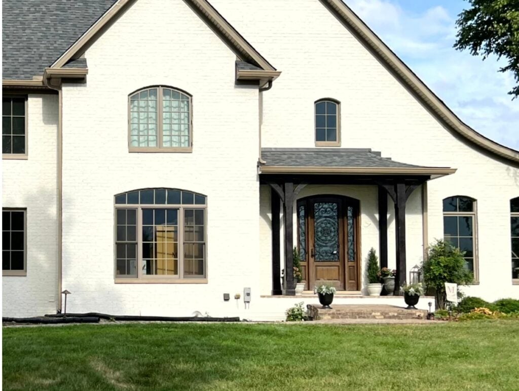 Benjamin Moore Sea Pearl, beautiful, best off-white warm paint color for an exterior, painted brick with taupe windows and gray roof, wood front door