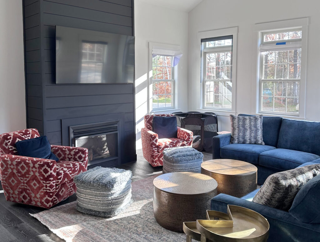 Benjamin Moore Super White walls, trims, ceiling, black shiplap fireplace accent wall, red pattern accent chairs, royal blue sofas, home decor, vaulted ceiling (1)