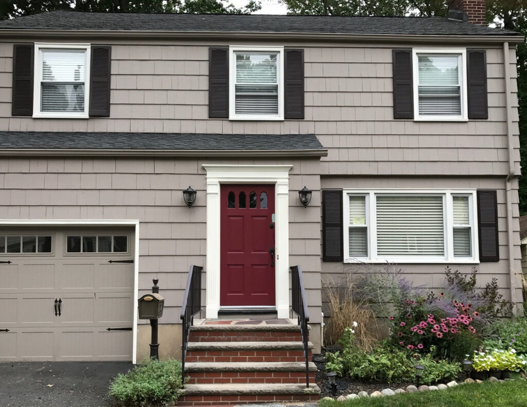 Benjamin Moore Weimaraner exterior siding of house, Dinner Party red painted front door, trim is Mascarpone. Gutter paint color matches house