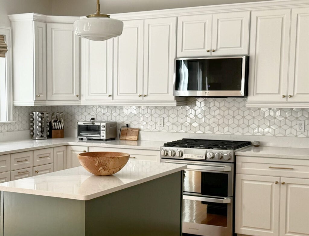 Benjamin Moore White Dove painted kitchen wood cabinets, Peale Green island, white quartz, patterned tile marble backsplash, golden oak flooring, Pearly White (Sherwin) walls