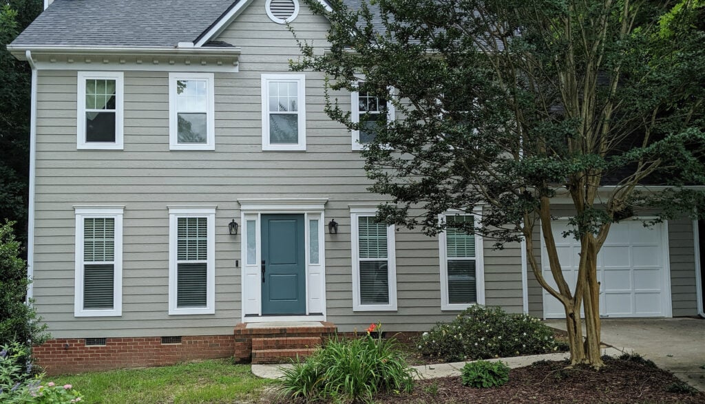 Exterior of home, siding painted Sherwin Williams Intellectual Gray, Riverway teal front door, Extra white trim, white gutters and windows, gray asphalt roof