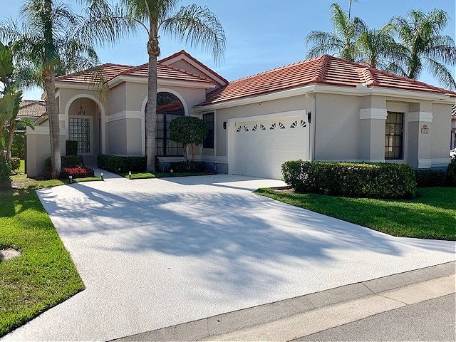 Exterior, red tile terra cotta roof, stucco before being painted with Kylie M Interiors Edesign. Greige stucco, warm, off-white paint color on trims and garage door. Florida style home slight mediterranean
