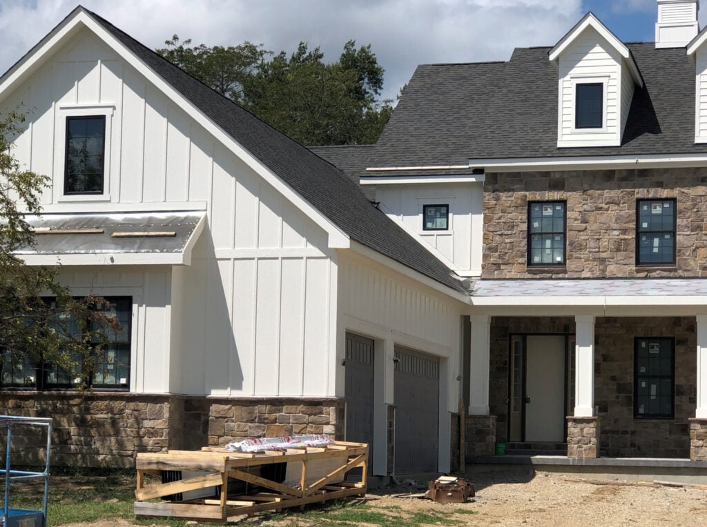 Exterior with brown brick and Sherwin Williams Greek Villa warm white paint colour. CLIENT PHOTO Kylie M INteriors edesign. Black windows, white gutters